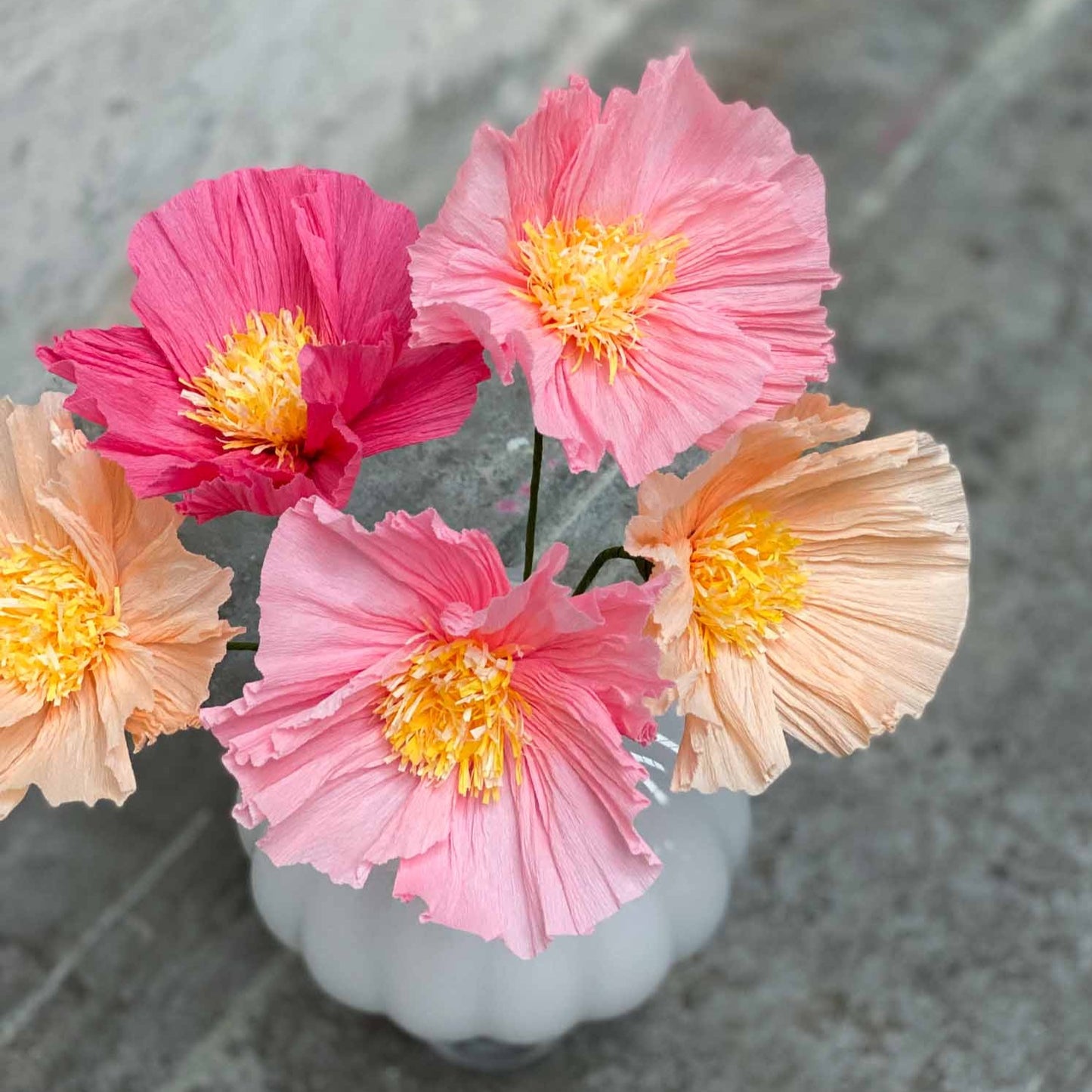 Gør-det-selv valmue i papir i laks og lyserød.